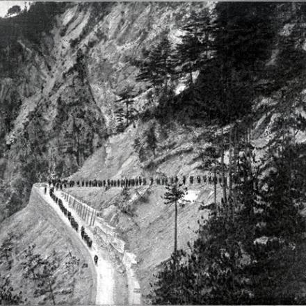 Sulle falde del Monte Nero, lungo una delle strade costruite dal Genio, reparti di truppa marciano verso le posizioni (Illustrazione)