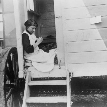 Una rifugiata belga si controlla le scarpe in una cabina su ruote a Ostenda, 28 agosto 1914. © IWM Q 53215