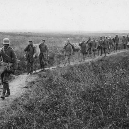 Lunga fila di feriti tedeschi trasportati su barelle improvvisate all'ospedale da campo più vicino, aprile 1917. © IWM (Q 87977)