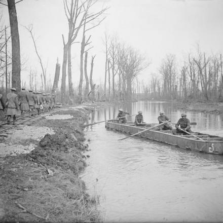 Cannonieri dell'Artiglieria Reale su una chiatta di munizioni lungo il fiume Scarpe e una squadra di Highlanders che cammina lungo una linea leggera, sulla riva, il 22 aprile 1917. © IWM (Q 5830)