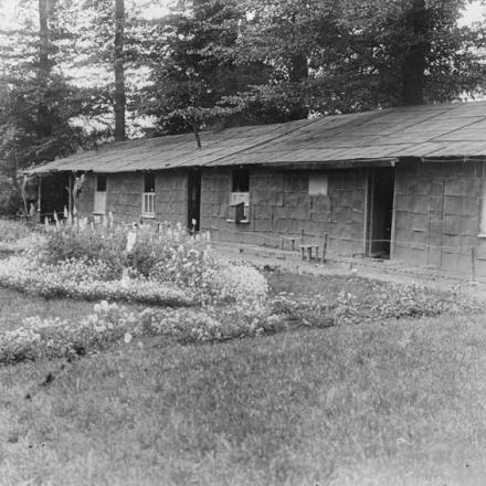 Alloggiamenti costruiti interamente con barattoli di benzina e con un giardino fiorito nella parte anteriore a Proven, il 29 luglio 1917. © IWM (Q 2648)