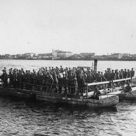 Truppe tedesche che attraversano il fiume Dvina (Daugava) a Riga su zattere trainate da un rimorchiatore, nel settembre 1917. © IWM (Q 86804)