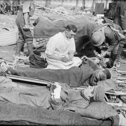 Un medico e un padre che si occupano di soldati britannici e tedeschi feriti durante la battaglia di Menin Road Ridge vicino a Potijze, 20 settembre 1917. © IWM Q 2857