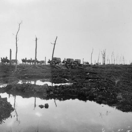 Una colonna di camion e veicoli trainati da cavalli si sposta lungo la strada di Menin verso sera. © IWM (E(AUS) 844)