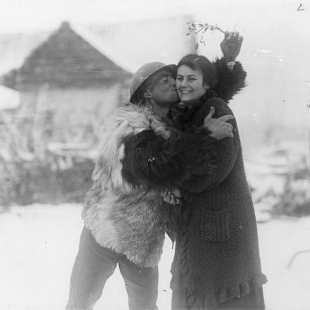 Un soldato del Machine Gun Corps con un cappotto di pelle di pecora bacia una contadina francese sotto un rametto di vischio, vicino a Hesdin, il 20 dicembre 1917. © IWM (Q 8354)