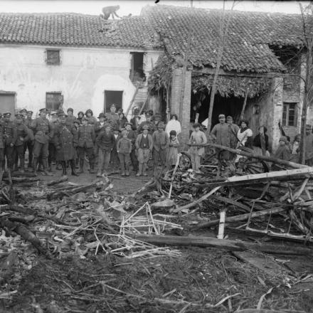 Poliziotti militari, soldati della Royal Artillery e abitanti di un villaggio italiano che guardano i resti di  un aereo austro-ungarico caduto in fiamme, 24 dicembre 1917. © IWM (Q 26545)