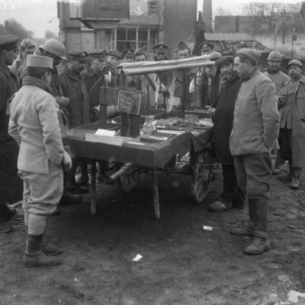 Le truppe britanniche e francesi si radunano intorno al carretto di un venditore ambulante a Ham sulla Somme, il 15 gennaio 1918. © IWM Q 10650
