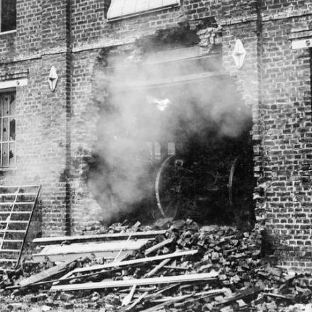 Un cannone da campo tedesco spara da un foro nel muro di un edificio in rovina a San Quintino. © IWM Q 56513
