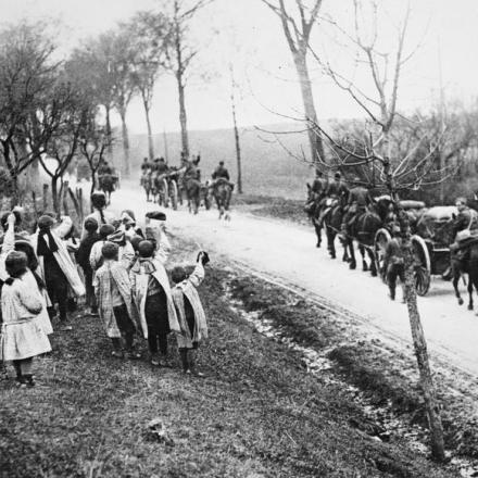 Bambini francesi salutano una colonna del 101st American Ammunition Train in marcia verso Soulosse, il 10 aprile 1918. © IWM (Q 85385)