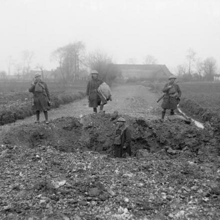 Cratere di una granata tedesca che ha completamente bloccato una strada. Vicino a Bethune, l'11 aprile 1918.  © IWM (Q 10891)