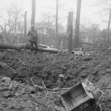 Bombardamento di Bethune nell'aprile del 1918. Soldati britannici in un buco di granata in un boschetto vicino a una strada a Bethune. © IWM (Q 10993)