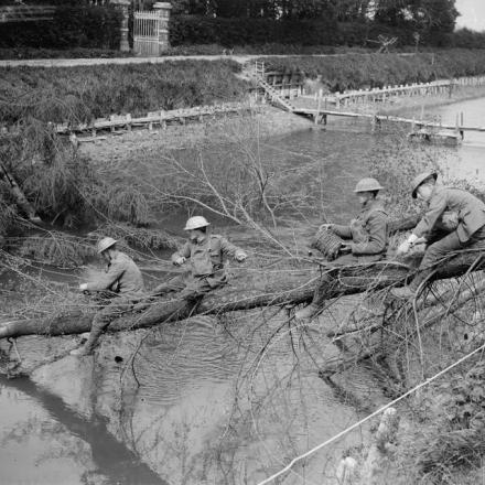 Battaglie del Lys. I Royal Engineers collegano gli alberi caduti sulla riva del canale Lys vicino a Saint-Floris per creare una  passerella temporanea sul canale, il 5 maggio 1918 © IWM (Q 6606)