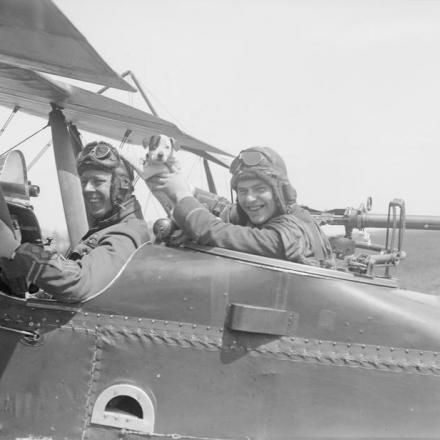 Pilota e osservatore di un biplano R.E.8 del 59° Squadrone con la mascotte. Aerodromo Vert-Galland, 15 maggio 1918.  © IWM