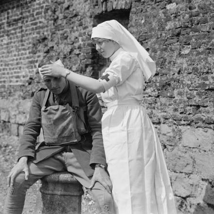 Un'infermiera del distaccamento volontario che fascia la testa di un ufficiale. Vicino a St. Pol, il 15 maggio 1918 © IWM