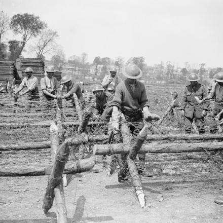 Soldati di uno dei battaglioni territoriali che fissano il filo spinato ai supporti. Vicino ad Arras, il 17 maggio 1918. © IWM (Q 8799)