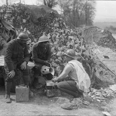 Cannonieri francesi e britannici si dividono l'acqua per lavarsi vicino a Villers-Bretonneux, il 4 maggio 1918. © IWM (Q 10946)