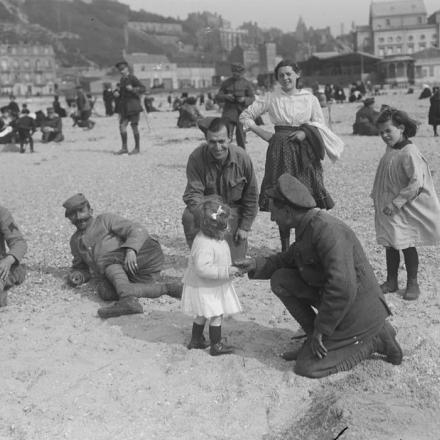Truppe francesi, americane e britanniche giocano con dei bambini sulla spiaggia di Boulogne, il 16 maggio 1918. © IWM 