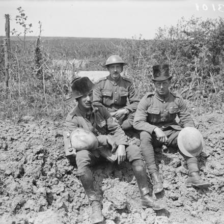 Tre soldati britannici indossano il copricapo teatrale durante un periodo di riposo a Hinges, il 18 maggio 1918. © IWM 