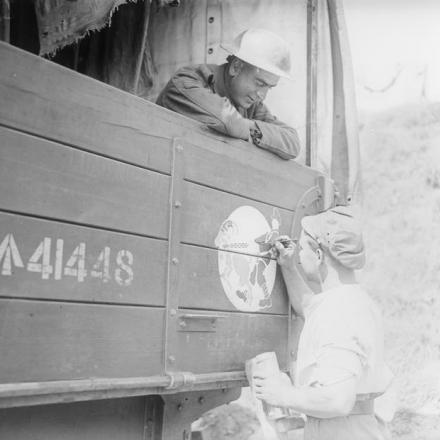 Soldato del Corpo di Servizio dell'Esercito che dipinge il marchio distintivo della Motor Transport Company su un camion di munizioni. Arras, 20 maggio 1918 © IWM 