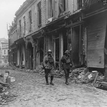 Poliziotti militari francese e britannico di pattuglia tra le rovine di Bethune, © IWM  indossando maschere antigas, il 20 maggio 1918.
