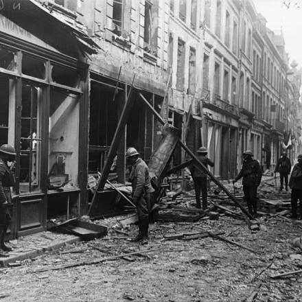 Poliziotti militari francesi e britannici, che indossano maschere antigas, in pattuglia a Bethune, il 20 maggio 1918 © IWM 