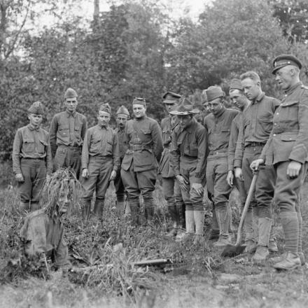 Uomini della 77a Divisione americana ricevono istruzioni di mimetizzazione dall'istruttore britannico di Moulle, il 22 maggio 1918. Il cecchino mimetizzato si mostra. © IWM 