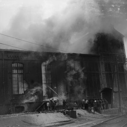 Un grande edificio industriale accanto alla ferrovia a Sailly-Labourse incendiato da un proiettile incendiario tedesco. I civili francesi stanno cercando di spegnerlo, il 4 giugno 1918.