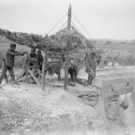 Lavoro dei Royal Engineers. Smaltimento del materiale scavato per realizzare punti di forza in una seconda linea a Basseux, il 14 giugno 1918. La terra scavata è sollevata in sacchi di sabbia da un verricello, che è schermato dall'osservazione aerea. La terra viene quindi portata via da un mono-rail. © IWM (Q 7902) 