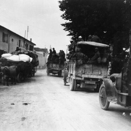 Rifugiati che si ritirano e truppe italiane che salgono su camion a motore sulla strada di Treviso, 1918. © IWM (Q 65242)