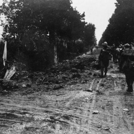 Le truppe italiane marciano davanti a un punto di soccorso distrutto vicino a Zenson sul Piave, nel giugno del 1918. © IWM (Q 65244)