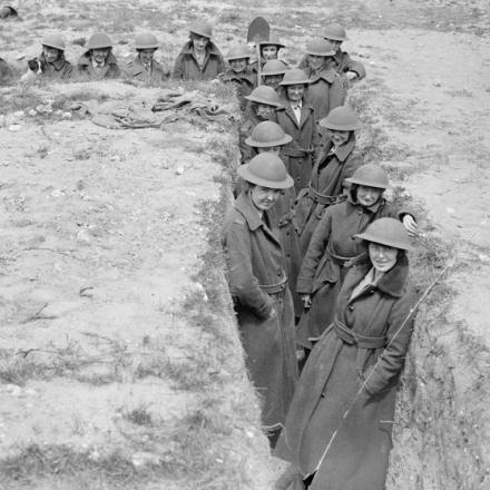 Membri del Queen Mary's Army Auxiliary Corps con elmetti d'acciaio in una trincea costruita per ripararsi in caso di un attacco aereo a Rouen, il 18 giugno 1918. © IWM (Q 3289)