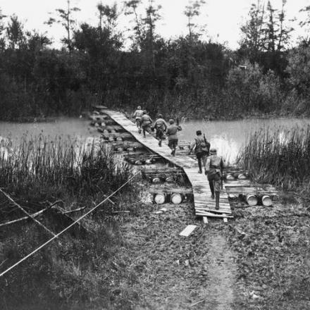 Truppe italiane che attraversano un ponte di barche (passerella n. 5) sul Piave, 1918. © IWM (Q 65290)