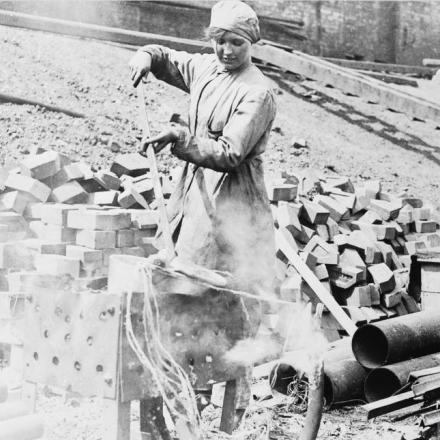 Catherine Burke, una dipendente della Govan Shipbuilding Yard, ha bruciato un cavo elettrico per recuperare piombo e rame a Glasgow, il 28 giugno 1918. © IWM (Q 110080)