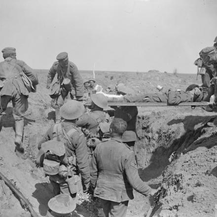 Cattura di Moyenneville. Prigionieri tedeschi che riportano feriti attraversando la vecchia linea tedesca, il 21 agosto 1918. © IWM (Q 6967)