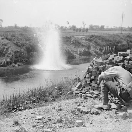Un Royal Engineer che pesca lanciando una bomba in un canale. Le Sart, 22 agosto 1918. © IWM (Q 6991)