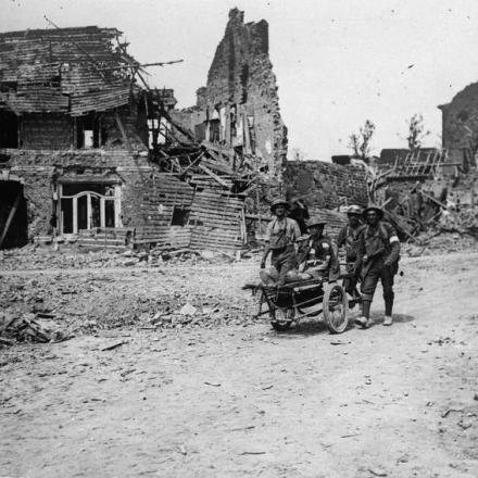 Inservienti del  Royal Army Medical Corps (RAMC) spostano un soldato ferito su una barella con ruote ad Albert, il 23 agosto 1918. © IWM (Q 78693)