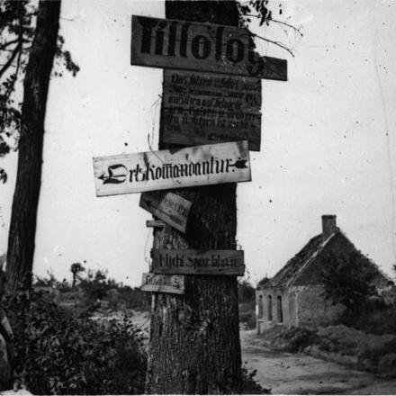 Un soldato francese controlla i segnali di direzione tedeschi su un albero all'ingresso del villaggio di Tilloloy, il 28 agosto 1918. © IWM (Q 78991)