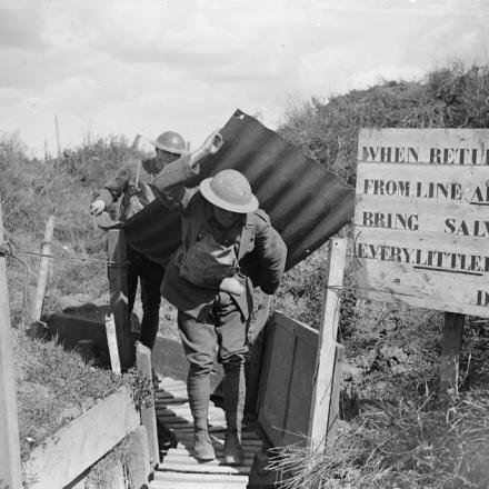 Truppe del 9 ° Battaglione, Royal Sussex Regiment, che portano un pezzo di lamiera sulla schiena come protezione. Near Lens, 3 settembre 1918.© IWM (Q 7032)
