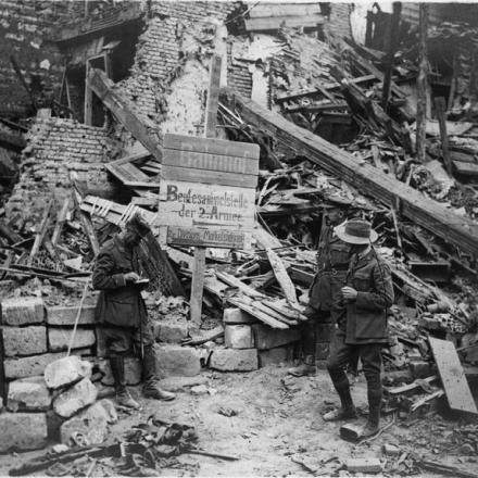 Ufficiali alleati che esaminano un cartello tedesco in mezzo alle rovine di Peronne, l'8 settembre 1918. © IWM (Q 78715)