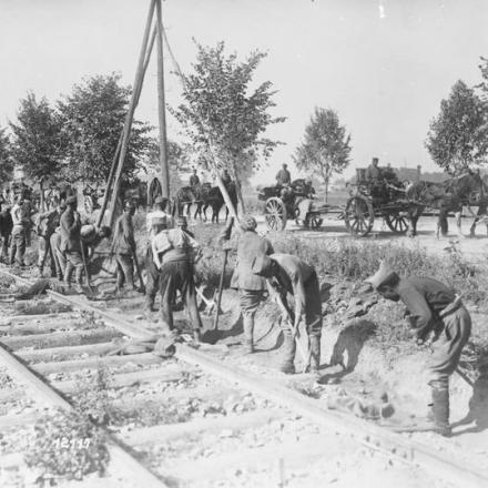 Artiglieria pesante tedesca lungo una strada, settembre 1918. Prigionieri di guerra francesi lavorano sulla linea ferroviaria. © IWM (Q 55404)