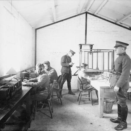 Segnalatori americani all'apparato radiofonico "Direction-Finding", usato in un bombardamento notturno, lavorano in una sala radio britannica, il 24 ottobre 1918. © IWM (Q 109766)