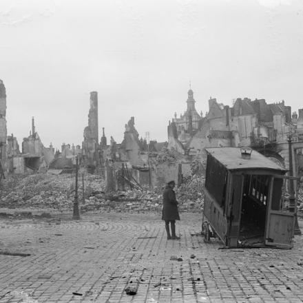 Soldato britannico che guarda il relitto di un tram nella Grande Place distrutta a Douai, il 25 ottobre 1918. © IWM (Q 11407)