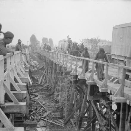 Trasporto trainato da cavalli e autoambulanza italiana che attraversano un ponte provvisorio costruito dai pionieri della 70a brigata, 23ª divisione a Sacile, 1918. © IWM (Q 26724)