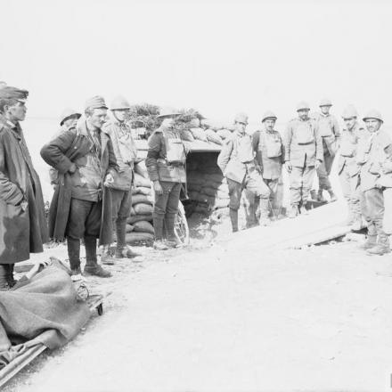 Truppe italiane e britanniche a guardia dei prigionieri austro-ungarici all'esterno di un rifugio sulle rive del fiume Piave, nel novembre del 1918. Fotografia probabilmente scattata vicino a Salettuol. © IWM (Q 26711)
