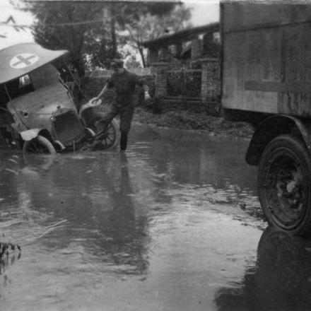 Un membro della n. 1 British Red Cross Society nella città allagata di Mossa (Gorizia), dopo che il suo veicolo si era bloccato.