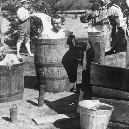 Truppe tedesche fanno il bagno in botti  di legno, da qualche parte sul fronte occidentale, nel 1915. © IWM (Q 53777)