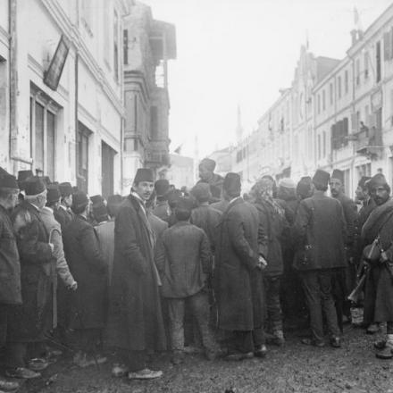 Uomini che si riuniscono per ascoltare un soldato serbo prima dell'evacuazione di Skopje. © IWM Q 52351