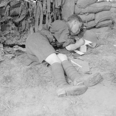 Un ufficiale britannico, steso a terra in una trincea catturata in Oostaverne Wood, scrive una lettera a casa, l'11 giugno 1917© IWM (Q 2308)