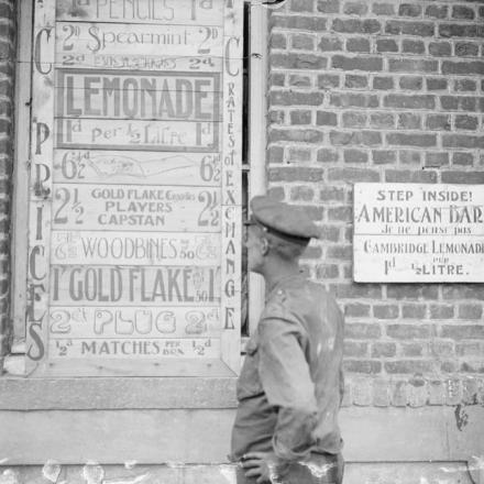 Soldato britannico che controlla una bacheca di un bar americano  a Givenchy, il 27 giugno 1917. © IWM (Q 5535)