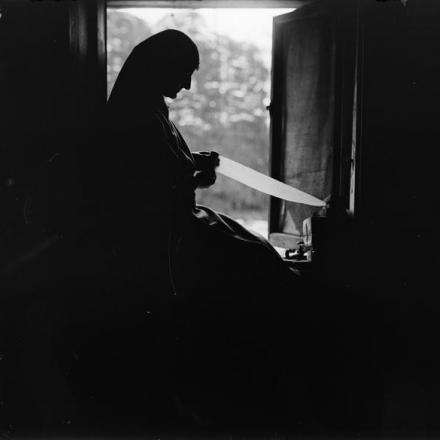 Elsie Knocker,  una delle due "Madonne di Pervyse", arrotola delle bende alla finestra, il 6 agosto 1917. © IWM (Q 2674)